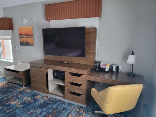 a room with a desk with a television and a chair at Hampton Inn & Suites Erie Bayfront in Erie