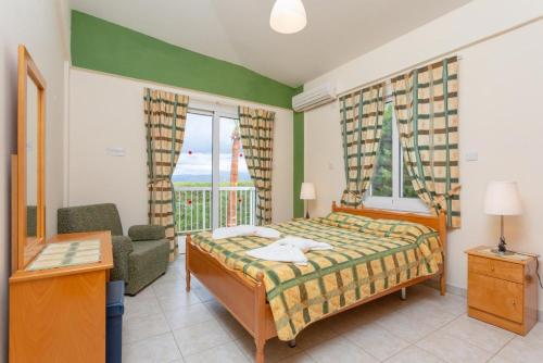 ネオ・チョリオにあるVilla Christia Marisのベッドルーム1室(ベッド1台、椅子、窓付)
