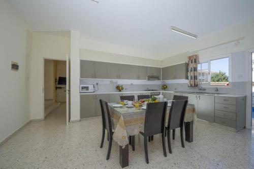 a kitchen with a table and chairs in a room at Villa Prodromi Large Private Pool AC WiFi in Prodhromi