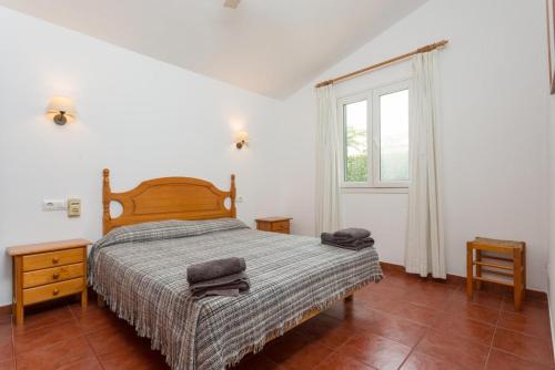 a bedroom with a large bed and a window at Villa Calitja Dos in Cala'n Bosch