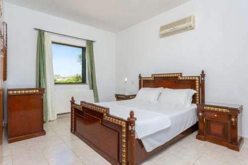 Un dormitorio con una cama grande y una ventana. en Villa Olivetta, en Kato Yialia