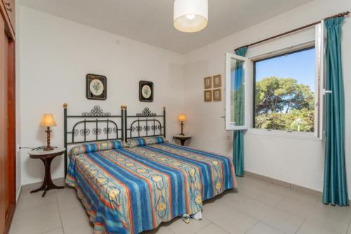a bedroom with a bed and a window at Villa Luisa in Cala Galdana