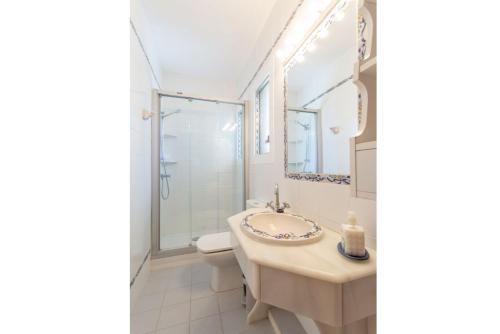 a bathroom with a sink and a toilet and a mirror at Villa Luisa in Cala Galdana