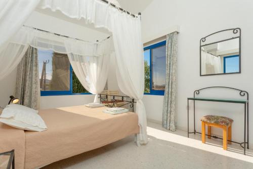 a bedroom with a bed and a mirror at Villa Charoula Ena in Polis Chrysochous