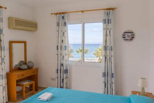 a bedroom with a bed and a window with the ocean at Villa Aspelia in Neo Chorio