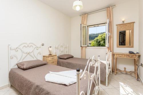 1 dormitorio con 2 camas y ventana en Villa Semeli, en Katelios