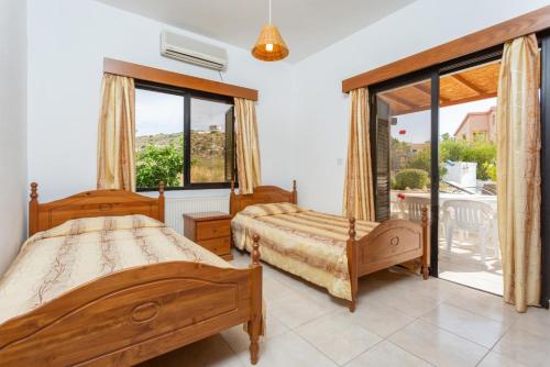 Cet appartement comprend une chambre avec deux lits et un balcon. dans l'établissement Villa Eleni, à Coral Bay