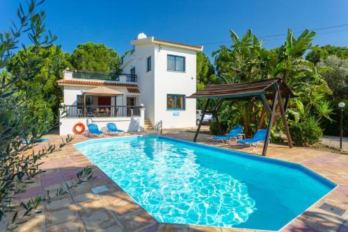 a villa with a swimming pool in front of a house at Villa Charoula Tria Large Private Pool AC WiFi in Paphos