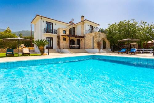 a villa with a swimming pool in front of a house at Villa Minoas in Argaka