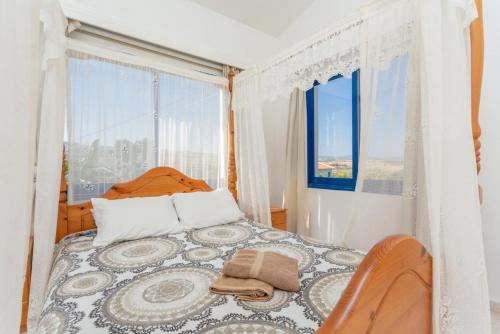 a bedroom with a bed and a large window at Villa Charoula Tria in Paphos City