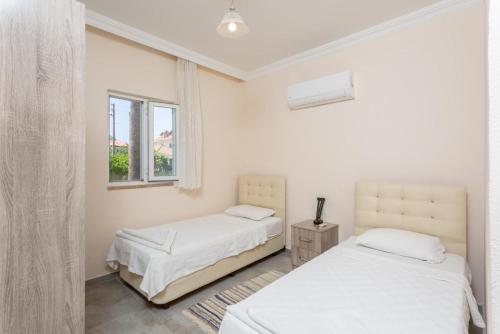 a bedroom with two beds and a window at Villa Duman 1 in Dalyan