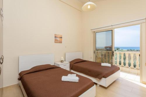 two beds in a room with a balcony at Villa Rose in Paphos City