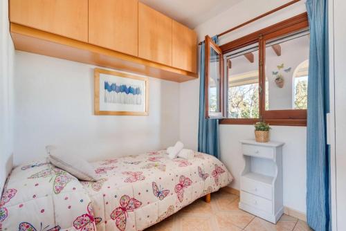 Schlafzimmer mit einem Bett und einem Fenster in der Unterkunft Villa Mari in Cala en Porter