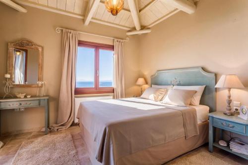 um quarto com uma cama grande e uma janela em Villa Diona em Panormos