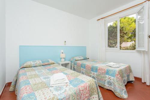 1 dormitorio con 2 camas y ventana en Villa Trepuco Dos, en Punta Prima