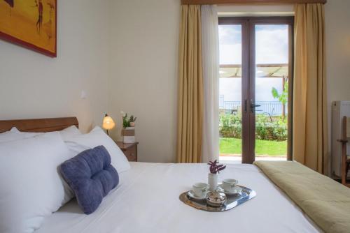 1 dormitorio con 1 cama blanca grande con almohadas azules en Villa Ilia, en Roussospítion