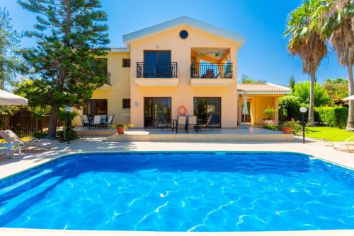 a villa with a swimming pool in front of a house at Villa Halima Stefanos in Polis Chrysochous