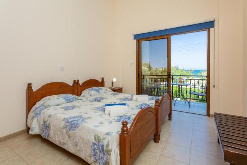 a bedroom with a large bed and a balcony at Villa Halima Stefanos in Polis Chrysochous