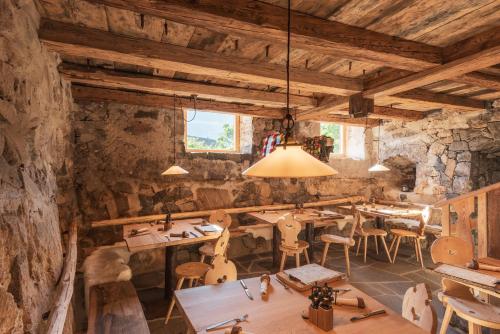 a restaurant with wooden tables and chairs in a room at Huberhof in Fiè