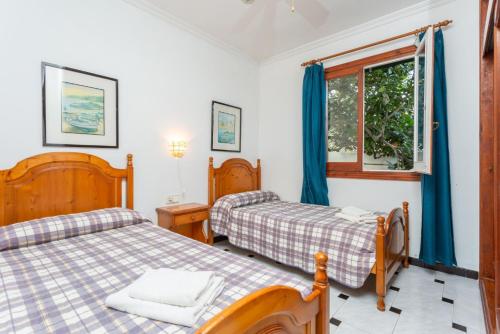 1 Schlafzimmer mit 2 Betten und einem Fenster in der Unterkunft Villa Emilio in Cala en Porter