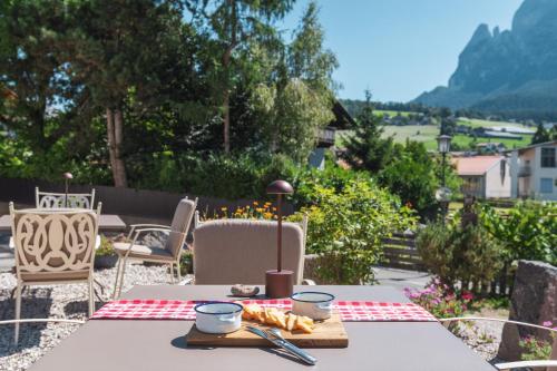 a table with a plate of food on a patio at Huberhof in Fiè