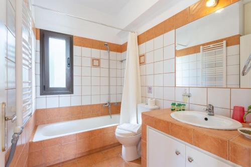 La salle de bains est pourvue d'un lavabo, de toilettes et d'une baignoire. dans l'établissement Villa Marina, à Svoronata