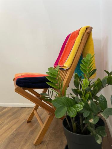 a colorful towel on a wooden chair next to a plant at Spacious modern apartments in Noord