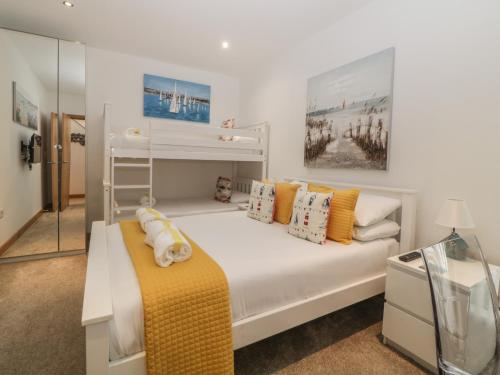 ein weißes Schlafzimmer mit einem Etagenbett und einem Spiegel in der Unterkunft 12 Beachdown in Kingsbridge