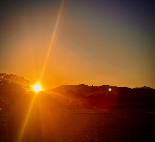 a sunset with the sun setting in the sky at Sunrise Sardinia Posada in Posada