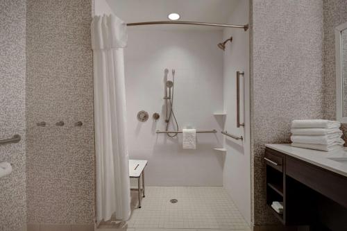 baño blanco con ducha y lavamanos en Home2 Suites East Hanover, NJ en East Hanover