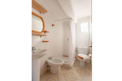 a white bathroom with a sink and a toilet at Villa Ca Nostra in Cala'n Porter