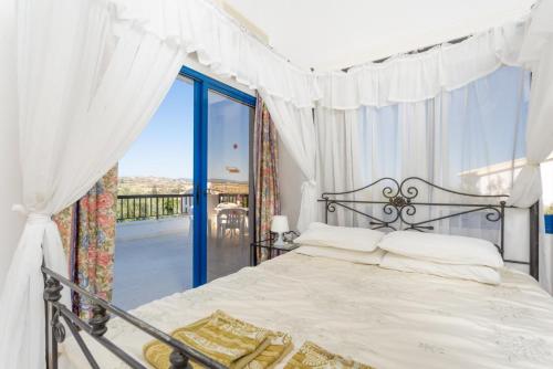 a bedroom with a bed and a balcony at Villa Charoula Thio in Polis Chrysochous