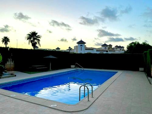 uma grande piscina azul em frente a uma casa em Casa de Don Simón em Cabo Roig