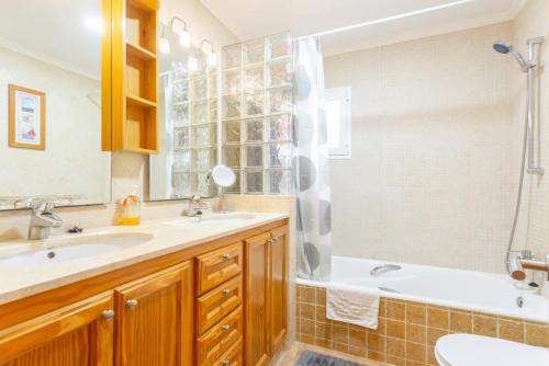 a bathroom with a tub and a sink and a shower at Villa Maria in Cala en Porter