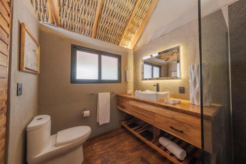 een badkamer met een toilet, een wastafel en een spiegel bij Nimue Marina Residence in Ajijic