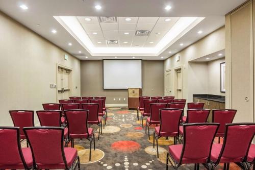 una sala conferenze con sedie rosse e schermo di Embassy Suites by Hilton Newark Airport a Elizabeth