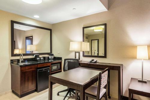 a hotel room with a desk and a table at Embassy Suites by Hilton Newark Airport in Elizabeth