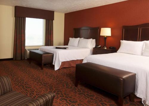 a hotel room with two beds and a chair at Hampton Inn & Suites Fargo Medical Center in Fargo