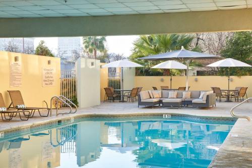 a pool with chairs and tables and umbrellas at DoubleTree by Hilton Fresno Convention Center in Fresno
