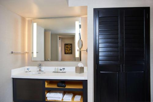 a bathroom with a sink and a mirror at DoubleTree by Hilton Fresno Convention Center in Fresno