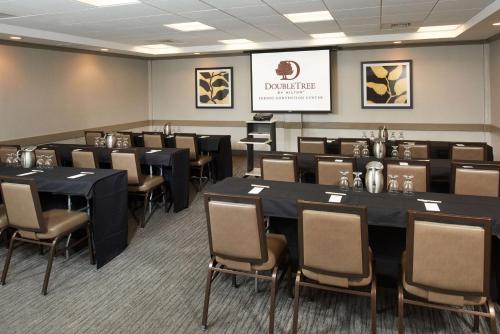 a conference room with tables and chairs and a screen at DoubleTree by Hilton Fresno Convention Center in Fresno