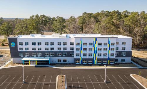 a large white building with a parking lot at Tru by Hilton Fayetteville I-95 in Fayetteville