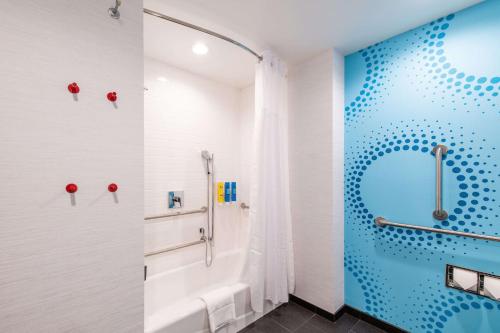 a bathroom with a shower and a white tub at Tru by Hilton Fayetteville I-95 in Fayetteville