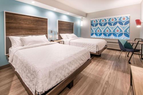 a hotel room with two beds and a chair at Tru by Hilton Fayetteville I-95 in Fayetteville