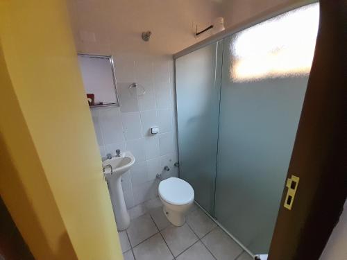 ボイスカンガにあるMandala casa 3 dorms cond fech piscina churrasqueiraのバスルーム(トイレ、ガラス張りのシャワー付)