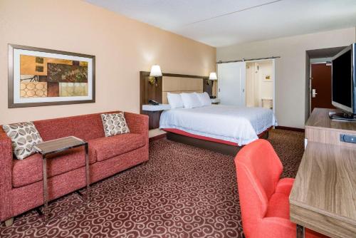 a hotel room with a bed and a couch at Hampton Inn Frostburg in Frostburg
