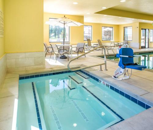 a swimming pool with chairs and a table in a building at Hampton Inn & Suites Whitefish in Whitefish
