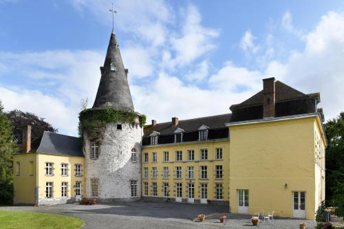 un grand bâtiment jaune avec une grande tour dans l'établissement Château de Bellignies, à Bellignies