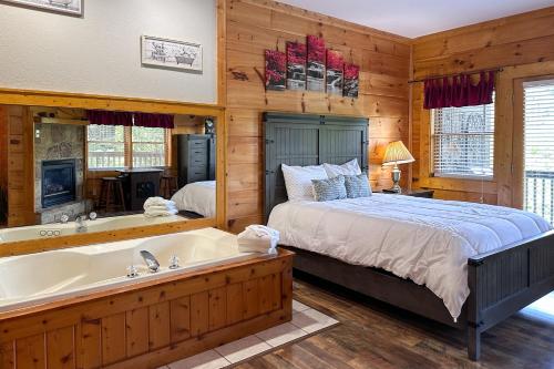 un dormitorio con una cama y una bañera en Reindeer Hideaway, en Pigeon Forge