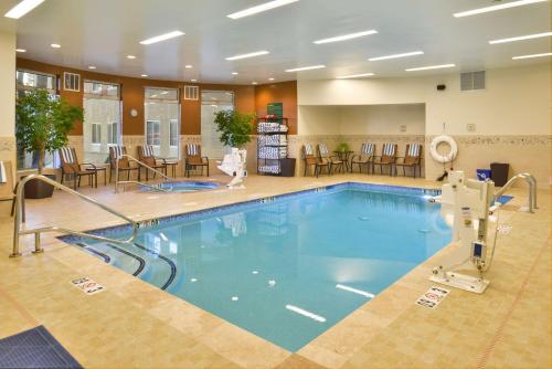 een zwembad in een hotellobby met stoelen en tafels bij Hilton Garden Inn Flagstaff in Flagstaff